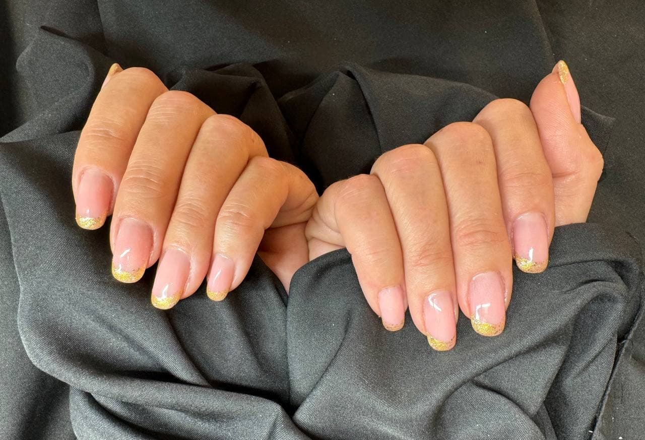 French manicure con punte oro glitter su unghie naturali