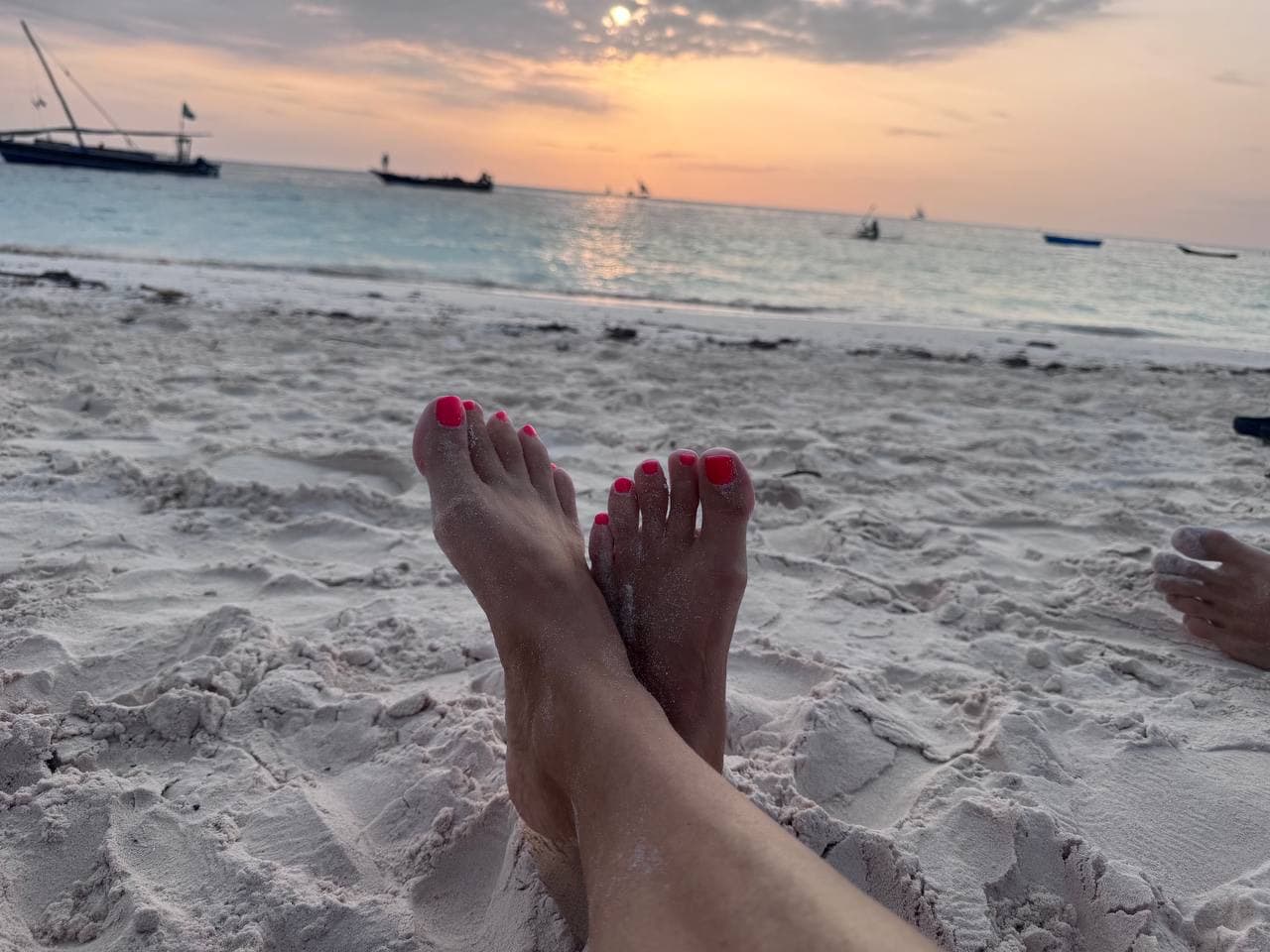 Pedicure rosso al tramonto in spiaggia